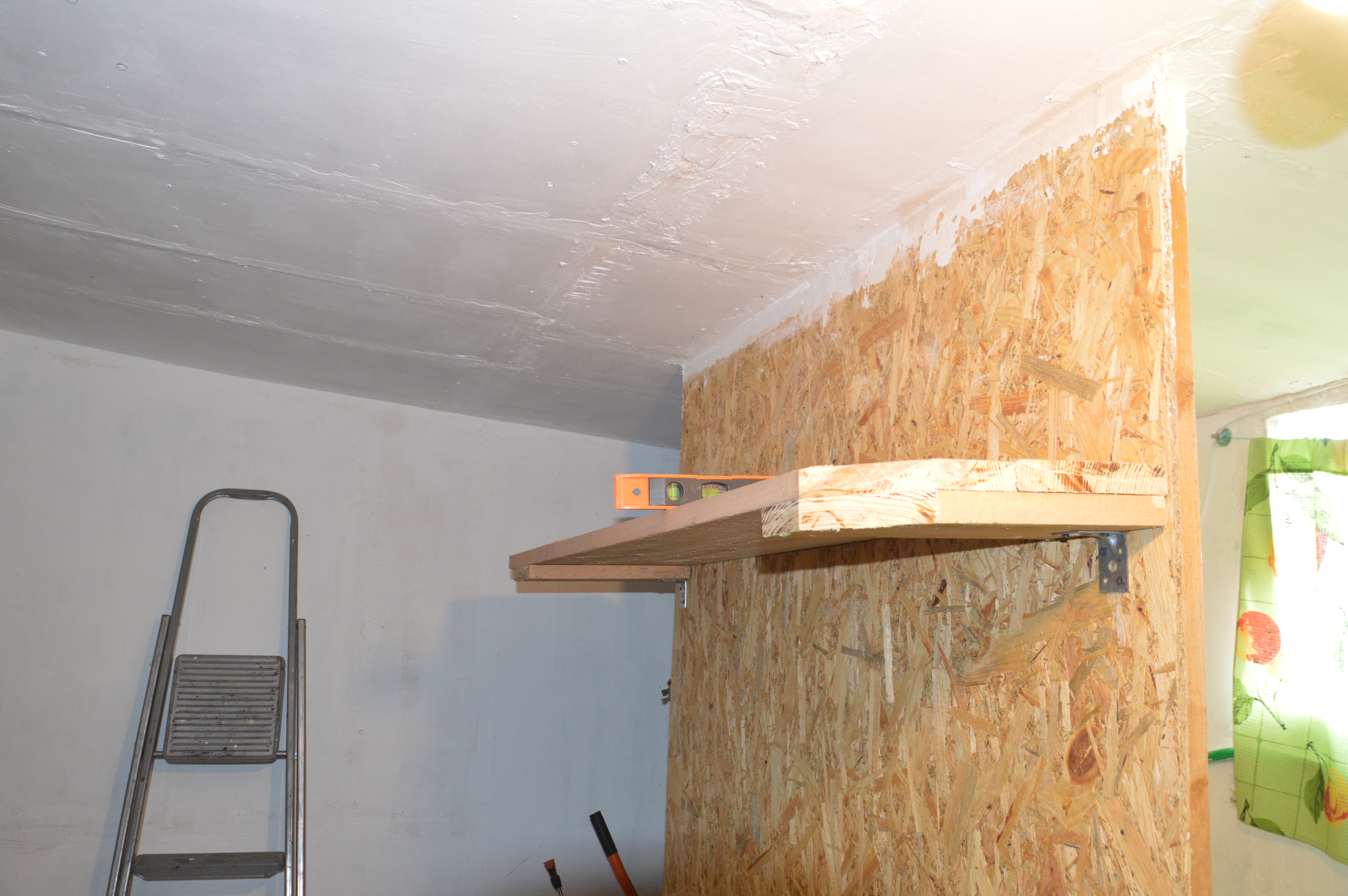 Handcrafted wooden shelf being assembled, with tools like a saw, hammer, and screws on a shelf, showcasing a DIY woodworking project