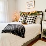 Cozy guest bedroom with festive Christmas décor, including a small tree, string lights, holiday bedding, and seasonal accents creating a warm, inviting atmosphere