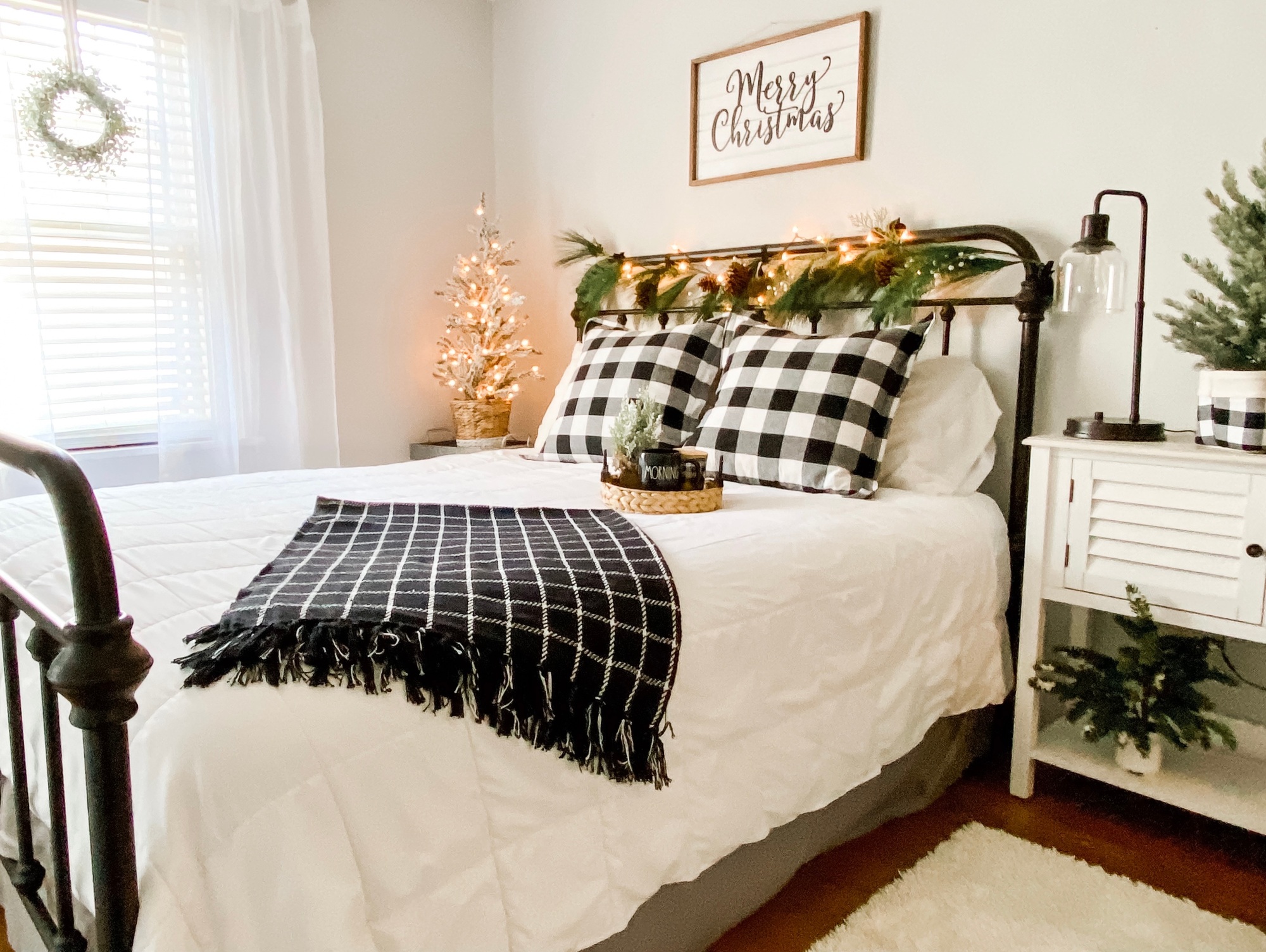 Cozy guest bedroom with festive Christmas décor, including a small tree, string lights, holiday bedding, and seasonal accents creating a warm, inviting atmosphere