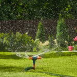 Automatic smart irrigation system in action, watering a lush garden in the backyard with a connected hose, ensuring efficient and even coverage