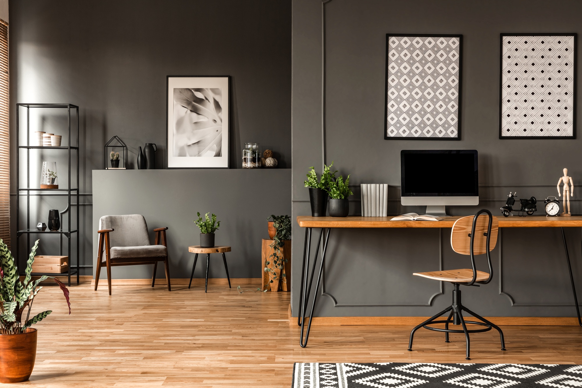 Stylish home office with grey walls, a modern desk, ergonomic chair, and sleek storage solutions, creating a calm and productive workspace.
