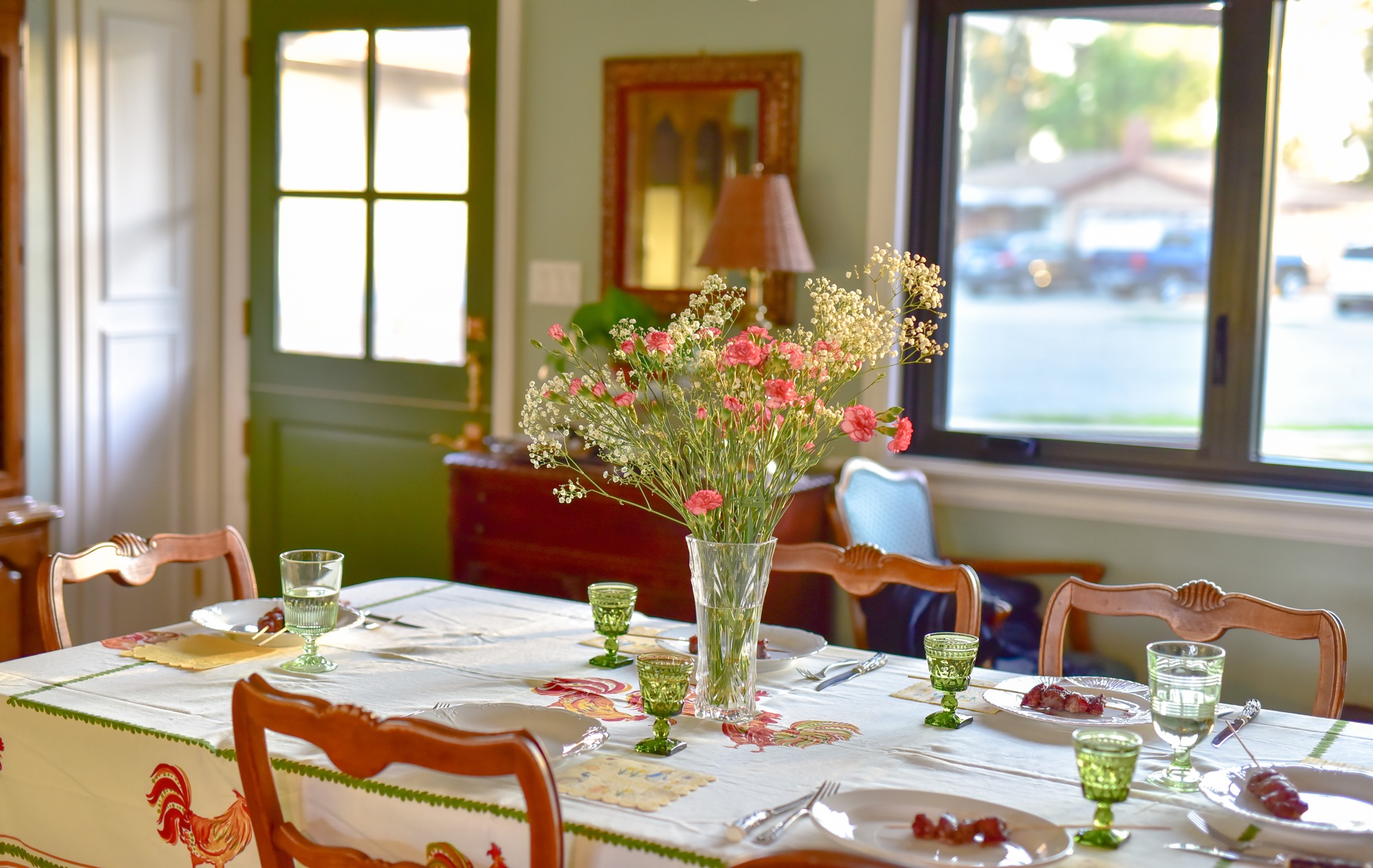 Elegant formal dining room table set for spring, featuring a crisp white tablecloth, floral centerpieces, fine china, and polished silverware, creating a welcoming atmosphere for family gatherings