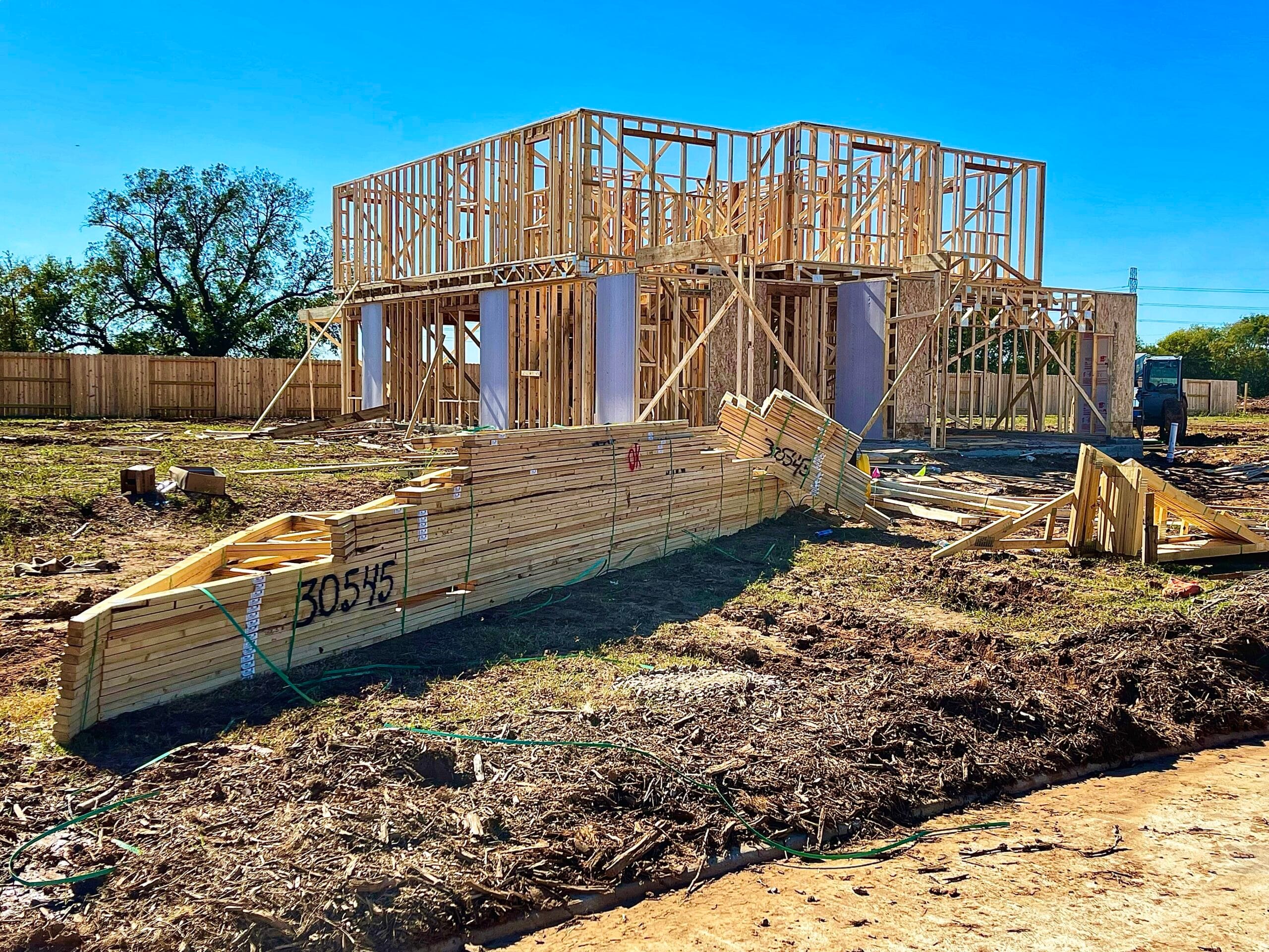 Framing stage of a custom home under construction by Meraki Builder in Huntsville, Texas.